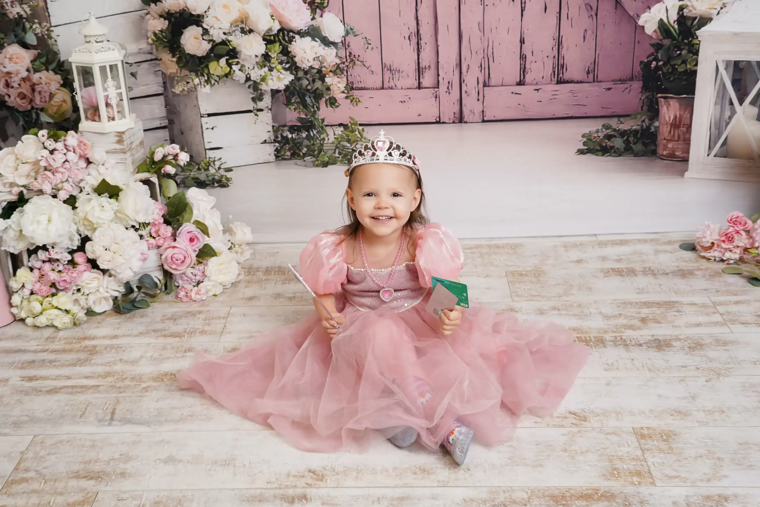 Child in pink princess dress holding a credit card, representing how simple contactless payments should feel.